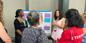 Ambassadors presenting a poster.