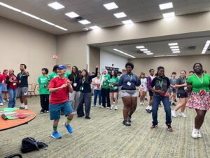 a group of teens dance in a large room